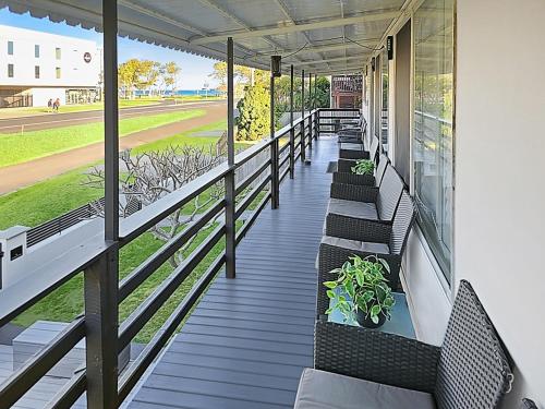 a porch with benches and a view of a baseball field at Skyes Beach House - The entertainer - Pet Friendly in Malua Bay