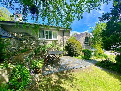 Llanbedr-y-cenninYr Hen Efail Cosy 1 bedroom Cottage, with fireplace and garden的石头小屋,花园内设有野餐桌