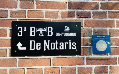 een teken op een stenen muur dat leest en de kennissen bij B&B de Notaris in Assen