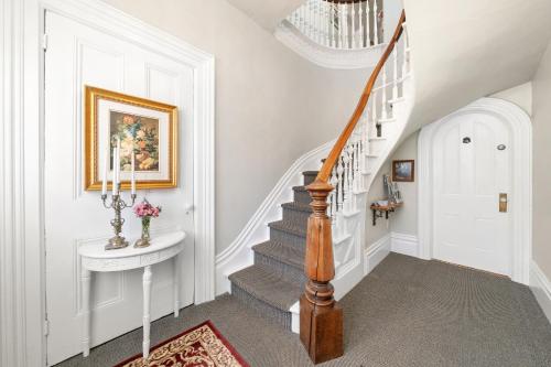 a staircase in a home with a white stair case at The 1885 Suites in Picton