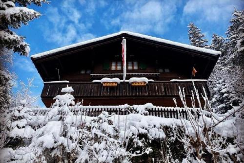 ein Blockhaus im Schnee mit Schnee in der Unterkunft Chalet Tannegüetli in Grindelwald