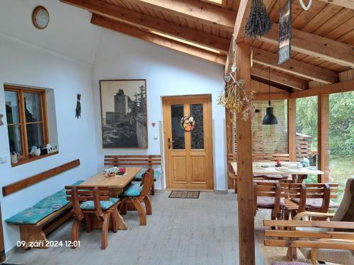 una sala da pranzo con tavolo e sedie in legno di Penzion Na Habeši a Kašperské Hory