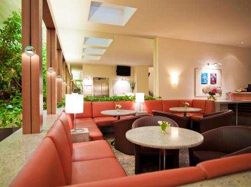 a restaurant with red couches and tables at Hotel Zipser in Vienna