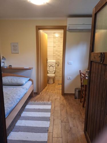 een badkamer met een bed en een toilet in een kamer bij Rooms Pri Lovrižu in Kobarid