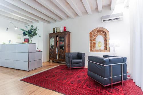 a living room with two chairs and a red rug at Relais Santa Corona in Vicenza