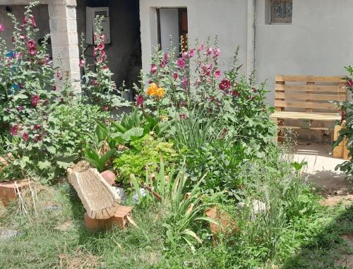 een tuin met bloemen en een bank voor een huis bij Los malbones in Cachí