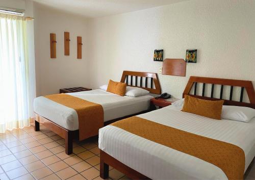 ein Hotelzimmer mit 2 Betten in einem Zimmer in der Unterkunft Hotel Maya Palenque in Palenque