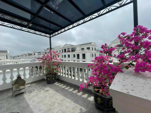 uma varanda com dois vasos de plantas e flores em SH17 Villa em Hai Phong