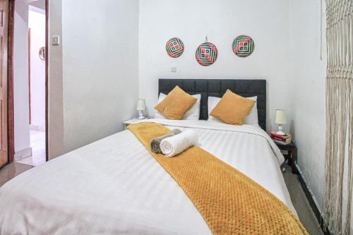 una camera da letto con un grande letto con cuscini arancioni di North Manor Nakuru a Nakuru