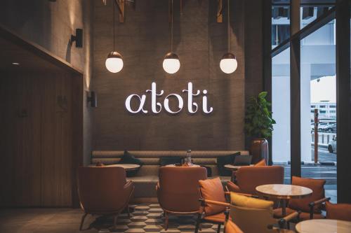 een restaurant met tafels en stoelen en een bord op de muur bij Mercure Miri City Centre in Miri