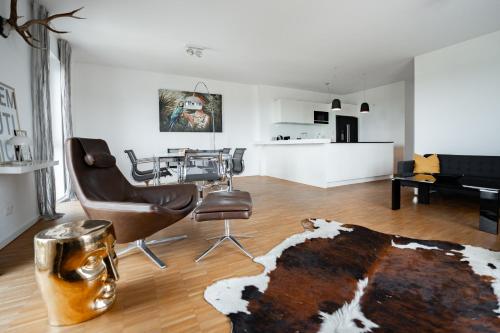 een woonkamer met een tafel en stoelen en een tapijt bij Prime Park Penthouse Aschaffenburg in Aschaffenburg