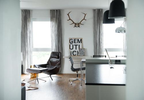 een woonkamer met een bureau en stoelen bij Prime Park Penthouse Aschaffenburg in Aschaffenburg