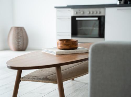 een houten tafel in een keuken met een kom op een boek bij Prime Park Deluxe Apartment Aschaffenburg in Aschaffenburg