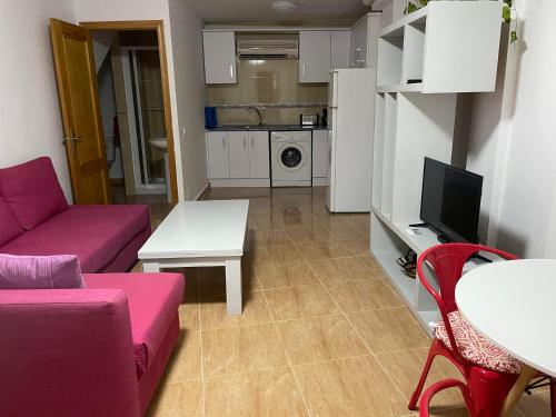 Apartamentos Dulcemar Frente al Mar con zona SPA في سان خوسيه: غرفة معيشة مع أريكة وطاولة