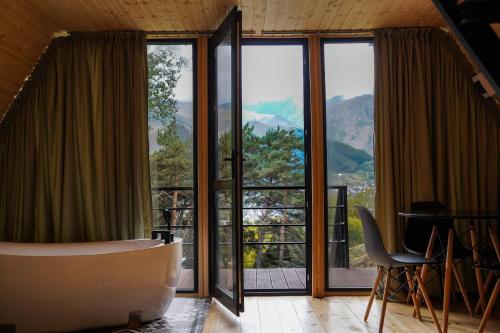 um quarto com uma grande janela com vista em Libertà Cottage Kazbegi em Kazbegi