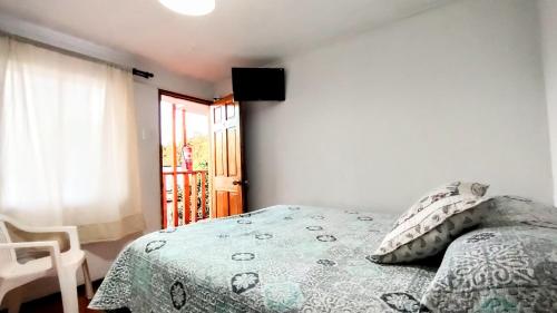 a bedroom with a bed with a green comforter at Habitacion y Baño Privado in La Serena