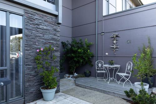 a patio with a table and chairs next to a building at Torquay Golf Retreats - Pool, Beach, Tennis, Golf in Torquay