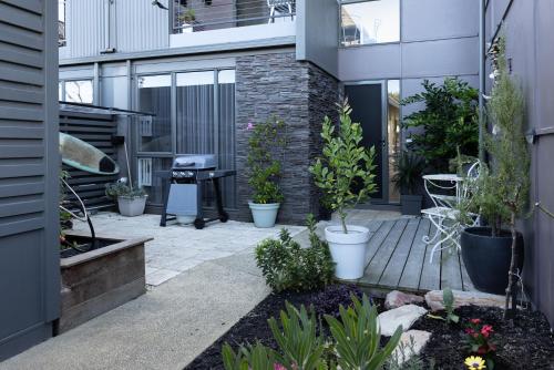 a courtyard with plants and a grill in a building at Torquay Golf Retreats - Pool, Beach, Tennis, Golf in Torquay