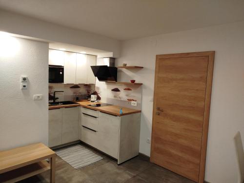 - une petite cuisine avec une porte en bois dans une chambre dans l'établissement Apartma Mamut 1850, à Kamnik