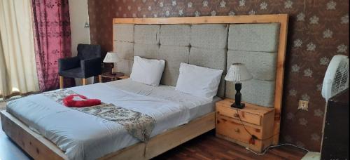 a bedroom with a large bed with a wooden headboard at Mount View Hotel Skardu in Skardu