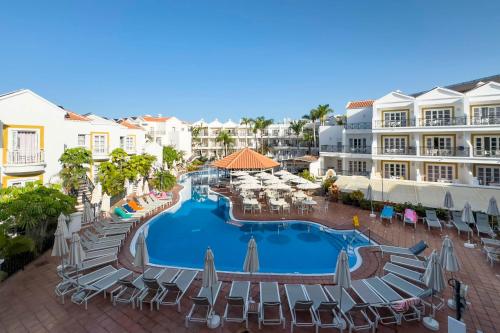 una vista aérea de una piscina del complejo con sillas y sombrillas en Apartamentos Parque del Sol, en Adeje