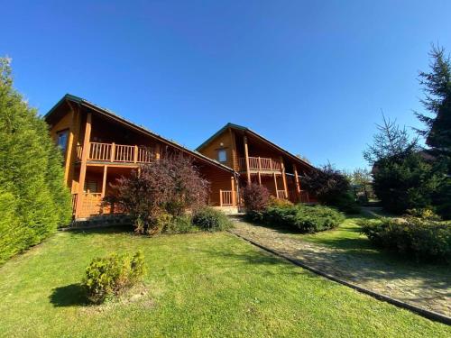 a large wooden house with a yard in front of it at Arnika in Skhidnitsa