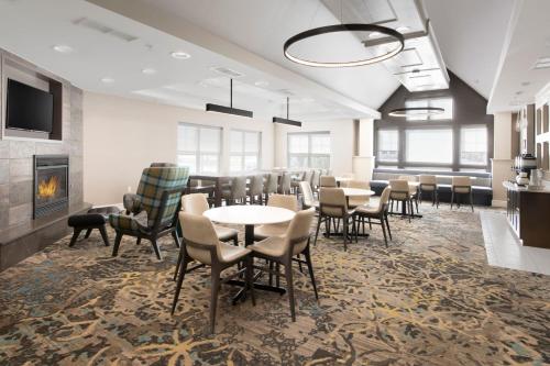 une salle à manger avec des tables, des chaises et une cheminée dans l'établissement Residence Inn by Marriott Rogers, à Rogers