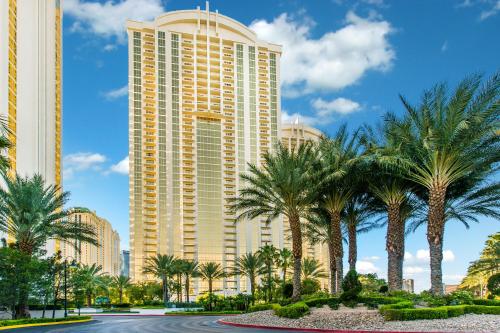 um grande edifício com palmeiras em frente em The Signature MGM Condos em Las Vegas