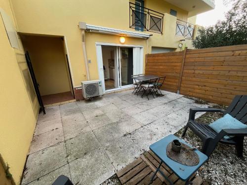 a patio with two chairs and a table in front of a house at Le Relais de la Calèche in Le Beausset