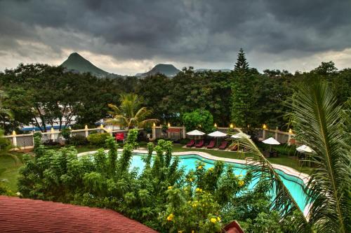 un complejo con piscina y montañas de fondo en Gateway Nashik, en Nashik