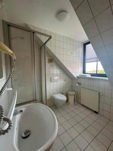 La salle de bains est pourvue d'un lavabo et de toilettes. dans l'établissement Land Hotell Ollendorf mit Event Location, 