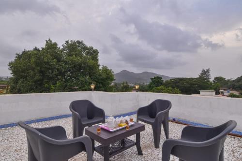 um grupo de cadeiras e uma mesa no telhado em EMPYREAN STAY ll 4BHK II KOHINOOR VILLA ll PRIVATE POOL II AC II LUXURY ll TUNGARLI em Lonavala