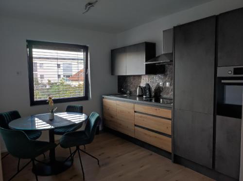 cocina con mesa y sillas y cocina con ventana en B&D apartment, en Maribor