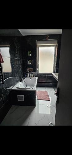 La salle de bains est pourvue d'une baignoire, d'un lavabo et d'une fenêtre. dans l'établissement Appart 150 m2 luxembourg à proximité, à Thionville