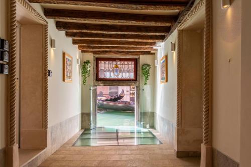 a hallway with a door to a canal with a boat at Numa Venice Palazzo Orseolo in Venice