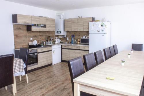 a kitchen with a table and chairs and a refrigerator at Air&Day in Vecsés