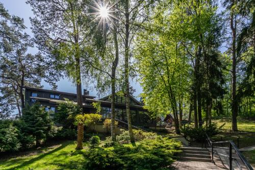 ein Haus inmitten eines Parks mit Bäumen in der Unterkunft "Seklytele" apartments in Birštonas