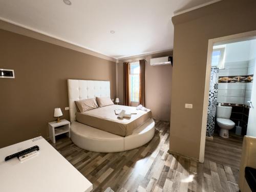 a living room with a bed and a bathroom at Shkodra Budget Hotel in Shkodër