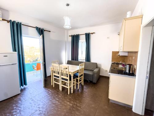 a kitchen and living room with a table and a couch at Shkodra Budget Hotel in Shkodër