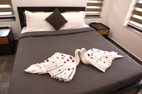 a bed with two towels with hearts on it at ECOSTAY inn in Sultan Bathery