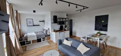 uma sala de estar com um sofá azul e uma cozinha em Charleroi Cozy Home em Charleroi