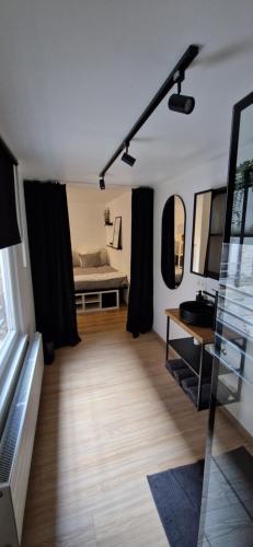 uma sala de estar com uma cama e cortinas pretas em Charleroi Cozy Home em Charleroi