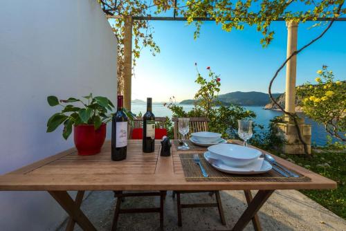 a wooden table with wine bottles and plates on it at Apartments Dia in Dubrovnik