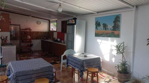 een keuken met 2 tafels en een tafel en stoelen bij Guest house on Devyatnadtsataya in Ureki