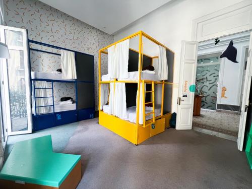 una camera con un letto a castello giallo e un tavolo di Viajero Montevideo Hostel a Montevideo