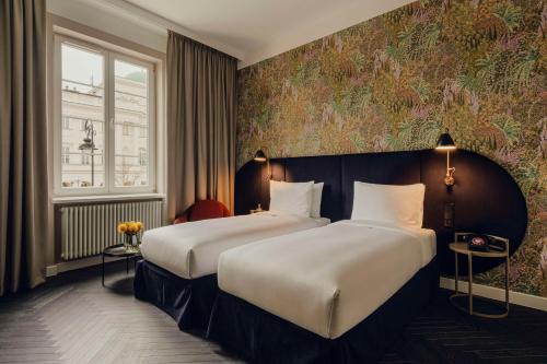 a hotel room with two beds and a window at Flaner Hotel, WorldHotels Crafted in Warsaw