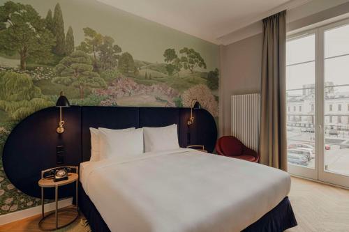 a bedroom with a large bed and a painting on the wall at Flaner Hotel, WorldHotels Crafted in Warsaw