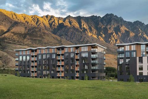 クイーンズタウンにあるLa Quinta by Wyndham Remarkables Park Queenstownの山々を背景にした大きなアパートメントビル