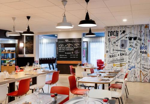 een restaurant met tafels en stoelen en een schoolbord bij B&B HOTEL Toulouse Université in Toulouse