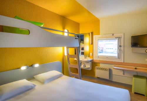 una camera con letto a castello e un bagno con lavandino di B&B HOTEL Cergy Pierrelaye a Pierrelaye